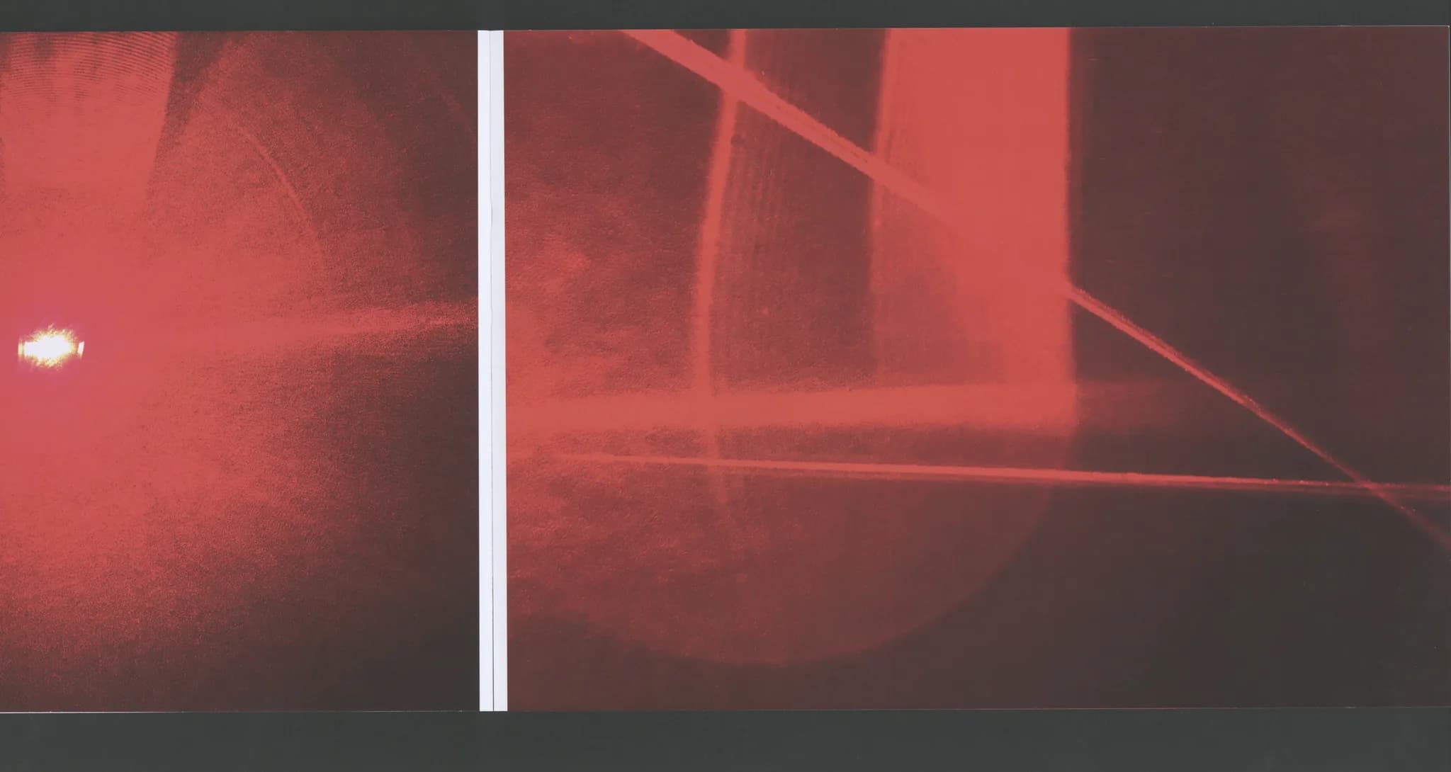 Book spread with full-bleed red laser glow against a dark room interior