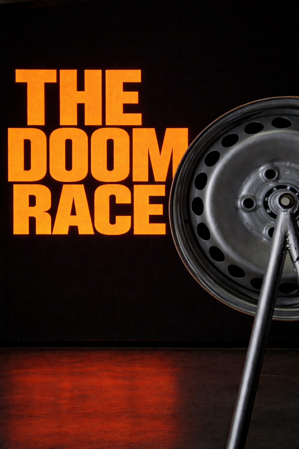 THE DOOM RACE title in orange block letters on black screen with wheel rim in foreground