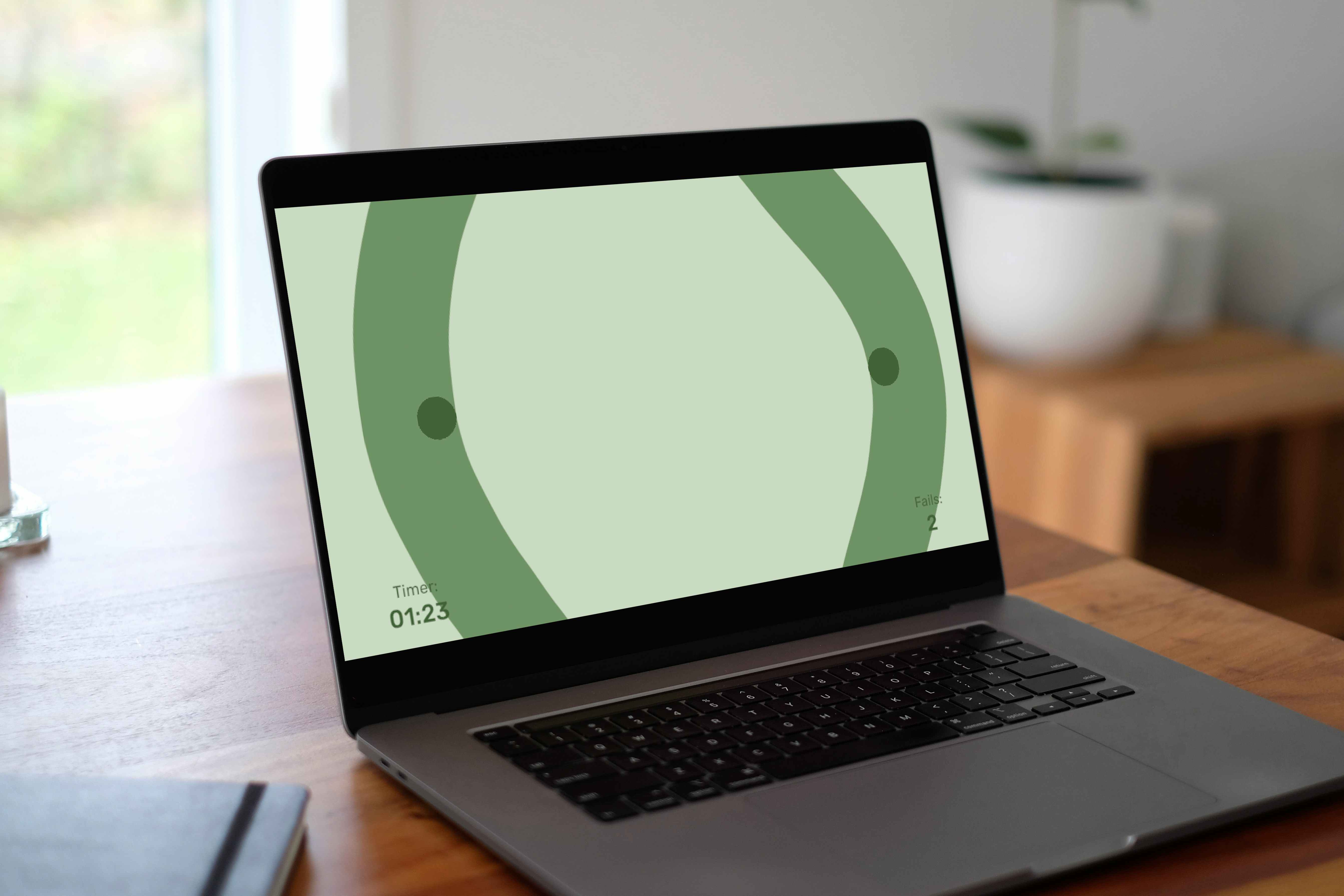 Laptop on a wooden desk showing the green circular steady-hand mini-game
