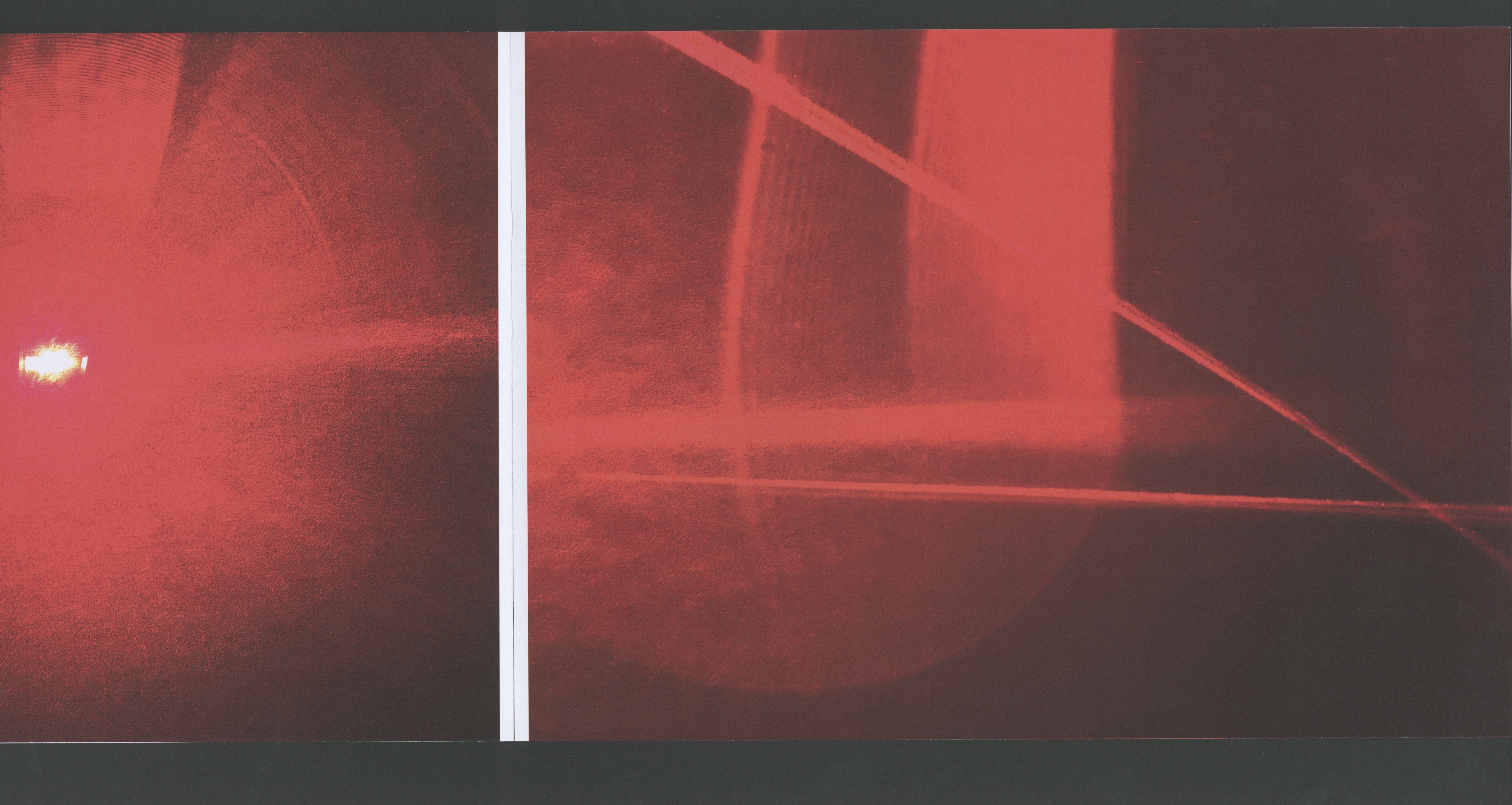 Book spread with full-bleed red laser glow against a dark room interior