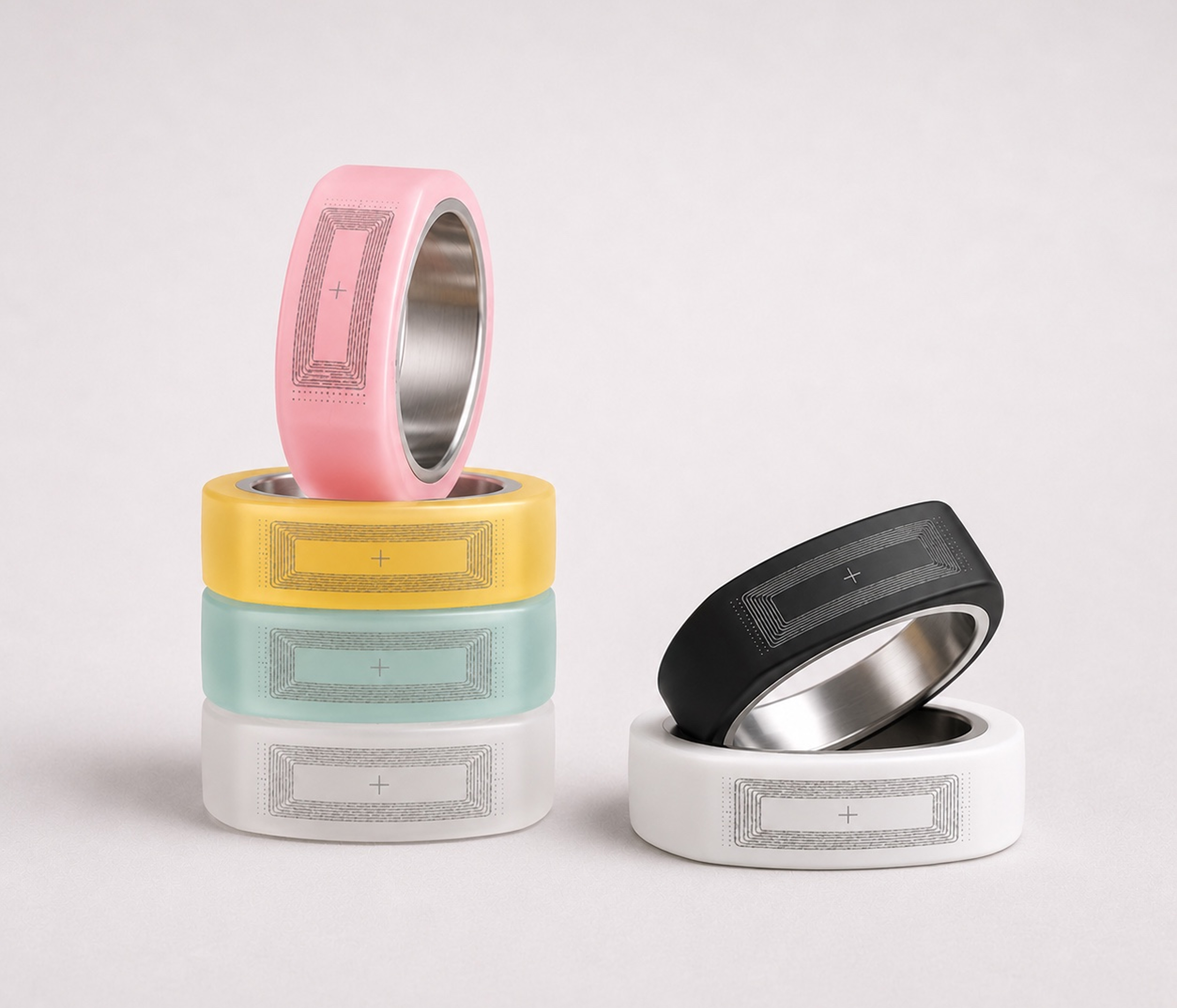 Stack of ONNN rings in pink, yellow, mint and white, with black and white rings beside them